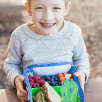boy with a squooshi reusable food pouch in a lunch box